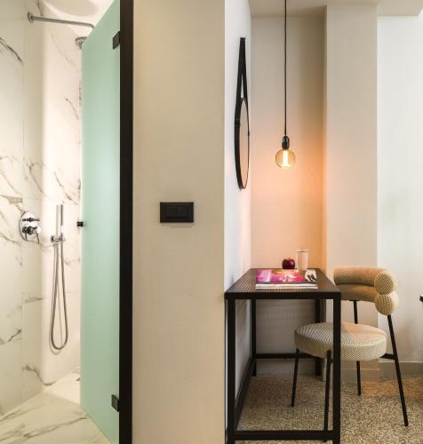 a bathroom with a table and chair and a shower at Anasa Hotel Athens in Athens