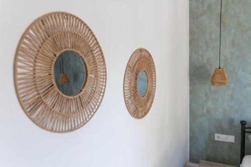 two wicker mirrors on a wall in a room at Villa Keyd Mare in Porto Rafti