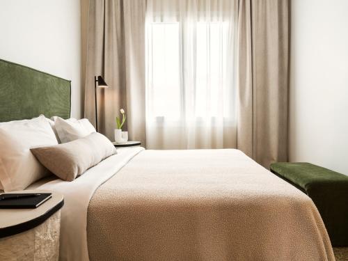 a bedroom with a large bed and a window at Anasa Hotel Athens in Athens