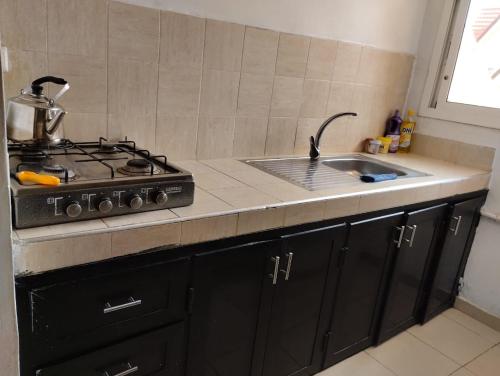 a kitchen counter with a stove and a sink at Dar Yasmine 2 in Ifrane
