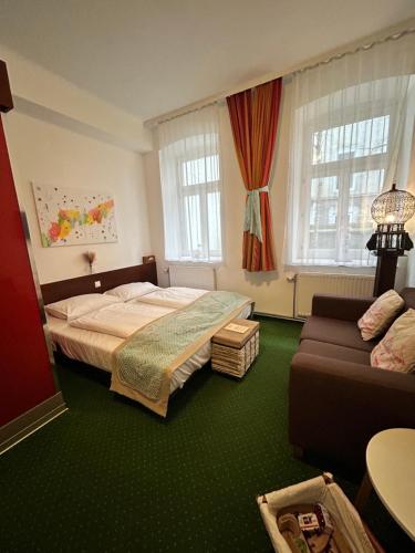 a bedroom with a bed and a couch at Pension Stadthalle in Vienna