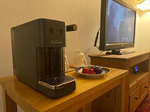 a coffee machine sitting on a table next to a television at York House Apartments in Romford
