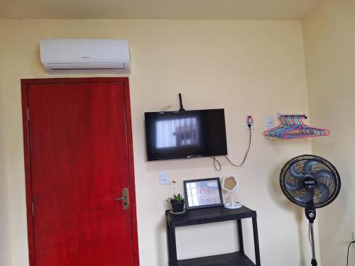 a room with a red door and a tv on the wall at Quarto UP perto do Centro e Praias AR TV Wifi Cozinha Lavadora in São Luís