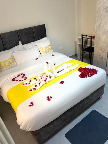 a large bed with red flowers on it at NayaLoft in Naivasha