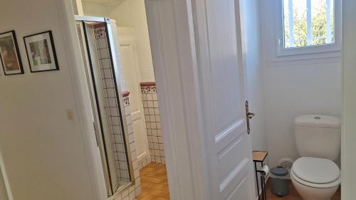 a white bathroom with a toilet and a window at Gite d'Ossau in Lescar