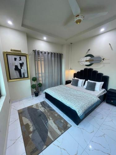 a bedroom with a king sized bed and a couch at Riverhills Comfort 2BHK in Rawalpindi