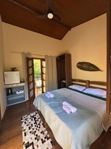 a bedroom with a bed with two towels on it at Hospedagem Arte na Cura in Guarapari