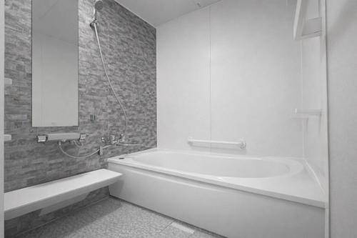 a white bathroom with a tub and a sink at 白樺 l リノベーション済 l 千歳空港まで30分 l 貸切の一軒家 l 8名様までOK in Yuni
