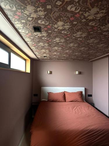 a bedroom with a bed with a floral ceiling at Casa Souburg in Oost-Souburg