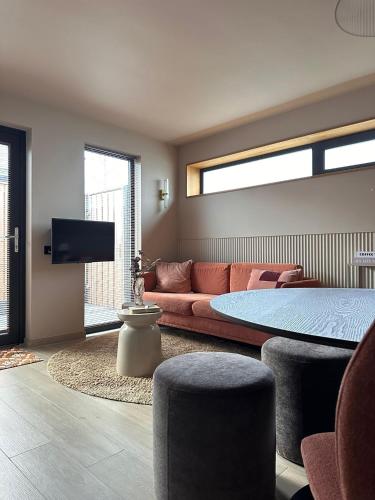 a bedroom with a bed and a couch and a tv at Casa Souburg in Oost-Souburg