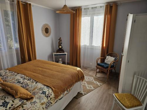 a bedroom with a bed and a chair and windows at L'Oustal in Saint-Constant