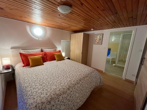 a bedroom with a bed with red and yellow pillows at A LA BELLE EPOQUE in Épernay
