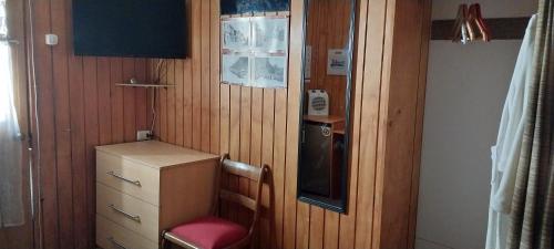 a small kitchen with a cabinet and a red chair at Victor-alojamientos in La Serena