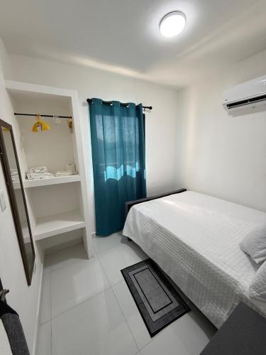 a bedroom with a bed and a blue shower curtain at Moon Apartamentos D3 in San Cristóbal