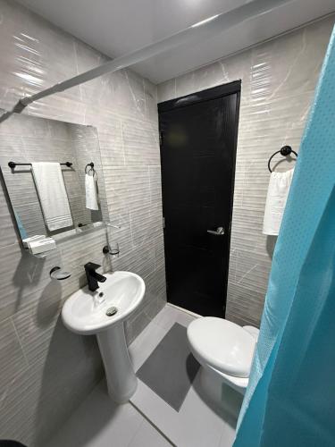 a bathroom with a white sink and a toilet at Moon Apartamentos D3 in San Cristóbal