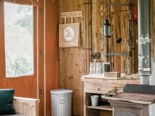 a kitchen with a counter in a wooden wall at 6-person Duynlodge Tent in Callanstoog in Callantsoog