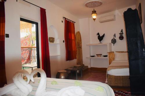 a bedroom with two swans on a bed and a window at Riad Vis Ta Vie in Marrakesh