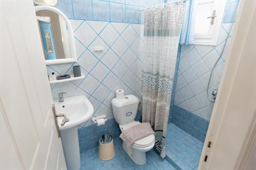 a blue tiled bathroom with a toilet and a sink at Socrates House Kythnos in Kithnos