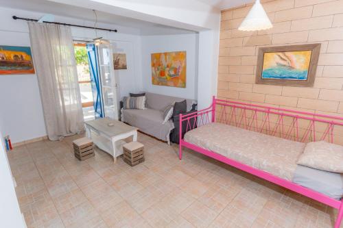a bedroom with a pink bed and a couch at Socrates House Kythnos in Kithnos