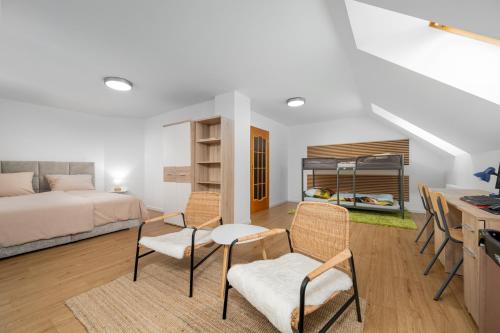 a bedroom with a bed and a desk and chairs at Apartmán Regina in Liberec