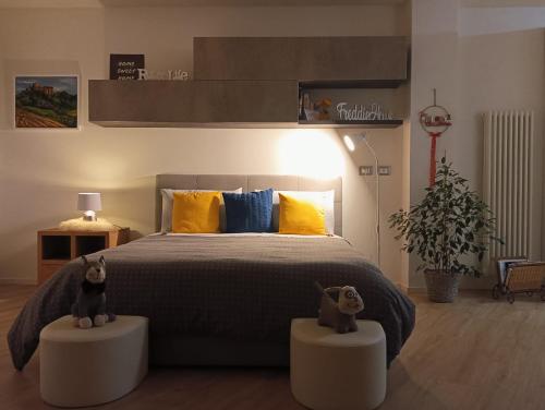 a bedroom with a large bed with two stuffed animals on stands at Freddie house in Albiano