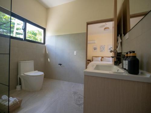a bathroom with a sink and a toilet and a window at Ocean View-picuzzi Villa RI duplex Las Galeras in Piedra de La Ballena