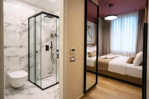 a bathroom with a shower and a toilet and a bed at Shkoder City Center - Floir Hotel in Shkodër