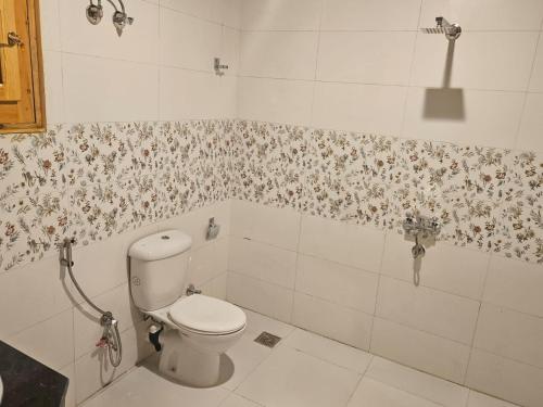 a bathroom with a toilet and floral wallpaper at Luxor Family Home in Naj‘ ar Rizqah