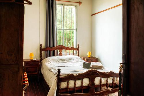 a bedroom with a wooden bed and a window at Posada San José de Lucas in Tupambaé