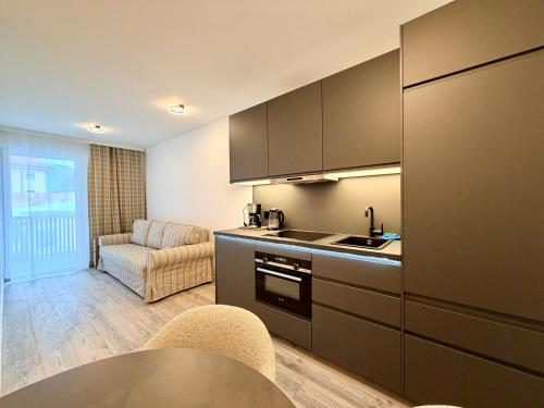 a kitchen with a sink and a couch in a room at GG Apartment 8 in Garmisch-Partenkirchen