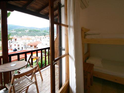 a room with a balcony with bunk beds and a table at ELIZA Skiathos in Skiathos Town