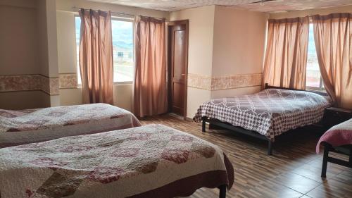 pokój hotelowy z dwoma łóżkami i oknem w obiekcie 9 de octubre w mieście Oruro