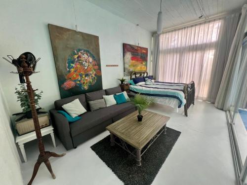 a living room with a couch and a bed at fascinating loft with swimming pool in Oaxaca City