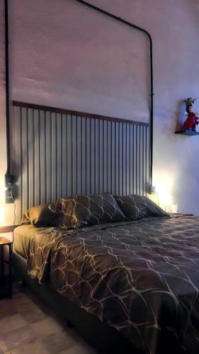 a bedroom with a bed with a metal head board at The Mercedes Room in Oaxaca City