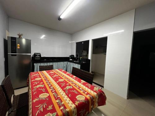 a kitchen with a table with a red blanket on it at Casa Completa brutomesso 3 in Londrina