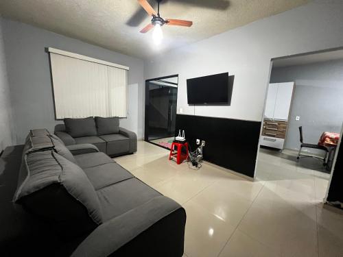 a living room with a couch and a flat screen tv at Casa Completa brutomesso 3 in Londrina