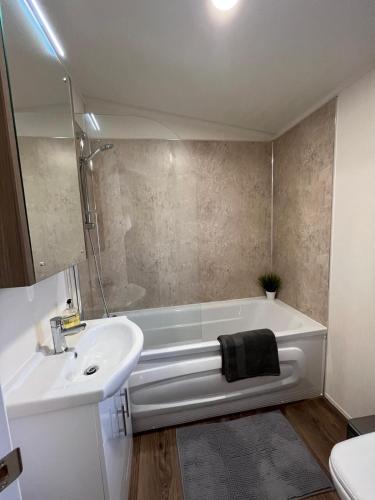 a bathroom with a white tub and a sink at Daffy Duck in Tydd Saint Giles
