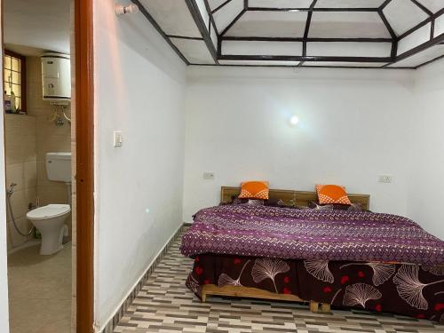 a bedroom with a bed and a toilet in a room at Nagwal Hotel in Dharamshala