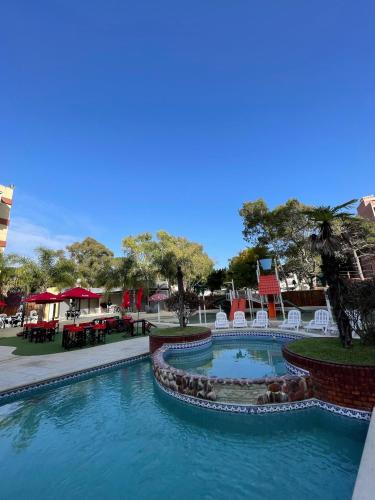 ein Pool in einem Resort mit Tischen und Stühlen in der Unterkunft Hotel Chiavari in San Bernardo