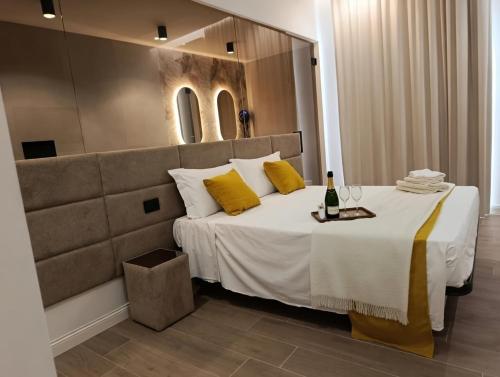 a bedroom with a bed with yellow pillows and a mirror at Ursino inn camere e suite in Catania