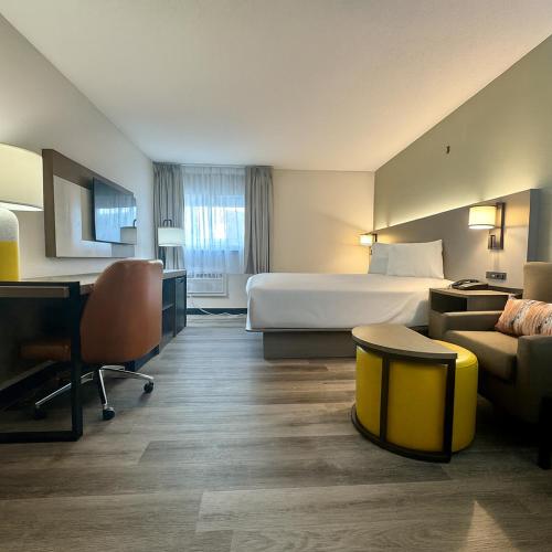 a hotel room with a bed and a desk at Dakota Inn in Minot