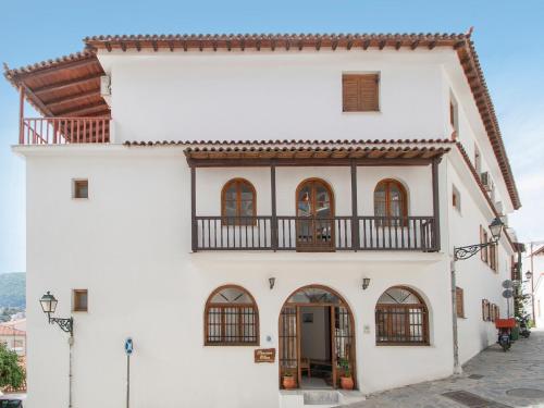 a white building with a balcony on a street at ELIZA Skiathos in Skiathos Town