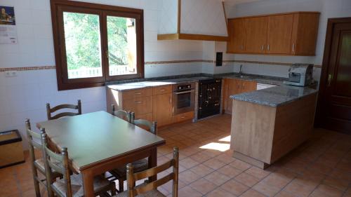 a kitchen with wooden cabinets and a table and a table and chairs at Arregi2 in Oñati