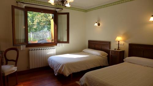 a bedroom with two beds and a window at Arregi2 in Oñati