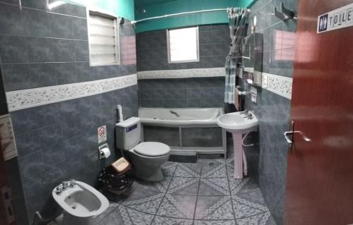 Un baño con inodoro, lavabo y bañera. en Space, en Cochabamba