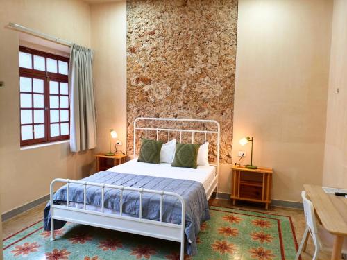 a bedroom with a bed and a wall at Villa Lara Palacios, tu oasis en Mérida in Mérida