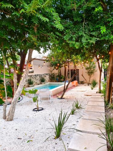 a swimming pool with chairs and trees in a yard at Villa Lara Palacios, tu oasis en Mérida in Mérida