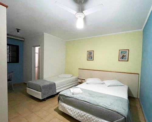 a bedroom with two beds and a ceiling fan at Central Park Hotel São Carlos - Fácil Acesso USP e Industrial - Ar condicionado in São Carlos