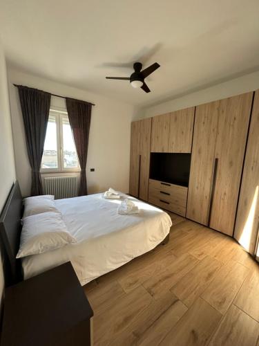 a bedroom with a bed and a flat screen tv at Luisella house in Isola Sacra
