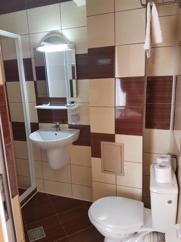 a bathroom with a toilet and a sink at Motel Imperial in Roman